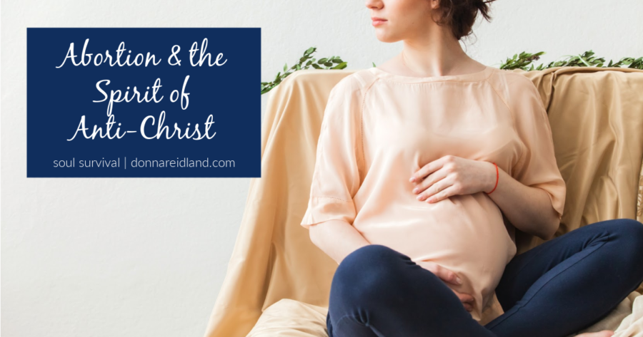 Pregnant woman in jeans and a peach colored blouse sitting cross-legged with text that reads, Abortion & the Spirit of Anti-Christ