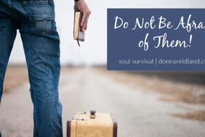 Man preparing to walk down a road with a suitcase and a bible with text that says, Do not be afraid of them!