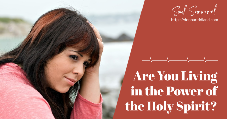 Depressed and discouraged woman with auburn hair sitting by the shore with text that reads, Are You Living in the Power of the Holy Spirit?