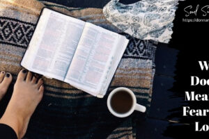 Woman's feet on a colorful blanket beside an open Bible and a cup of coffee with text that says, What Does It Mean to Fear the Lord?