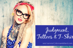 Young woman with tattoos and a red bandanna with text that reads, Judgment, Tattoos & T-Shirts.