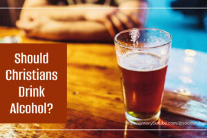 Glass of beer sitting on a bar with text that reads, Should Christians Drink Alcohol?